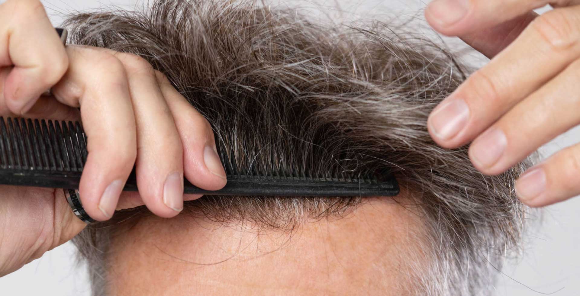 Close-up of a human hair system being brushed